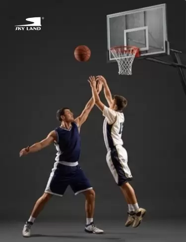 Two basketball players competing for a shot using a SKY LAND basketball hoop during an intense game.